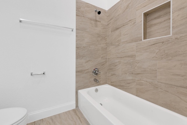 bathroom featuring shower / tub combination, toilet, a skylight, wood finished floors, and baseboards