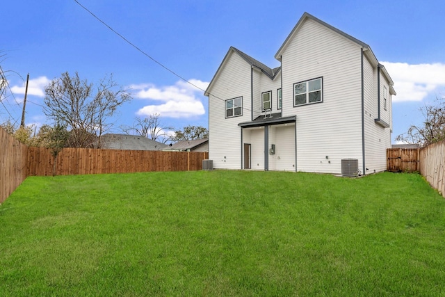 rear view of property with a lawn, cooling unit, and a fenced backyard