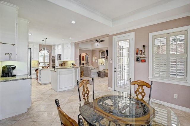 dining area with arched walkways, light tile patterned floors, recessed lighting, baseboards, and ornamental molding