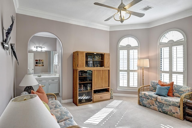 living area featuring light carpet, arched walkways, and crown molding