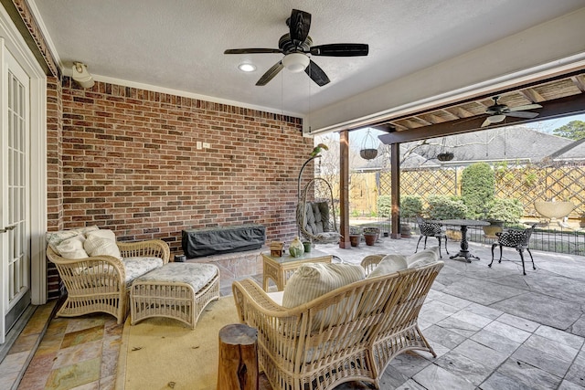 view of patio featuring outdoor dining area, ceiling fan, fence, and an outdoor hangout area