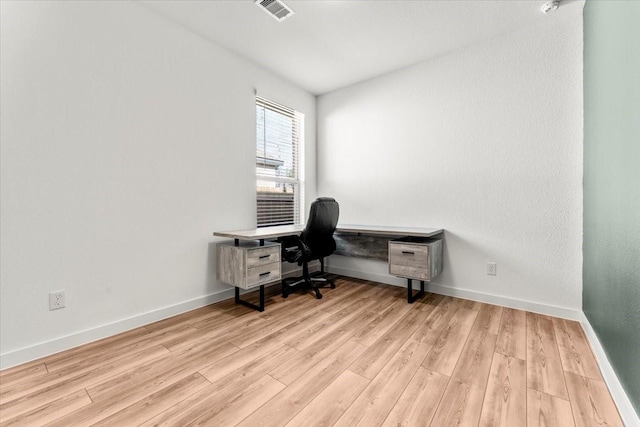 office area featuring light wood-style floors, baseboards, and visible vents