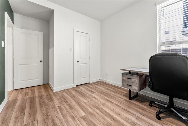 home office with light wood finished floors and baseboards