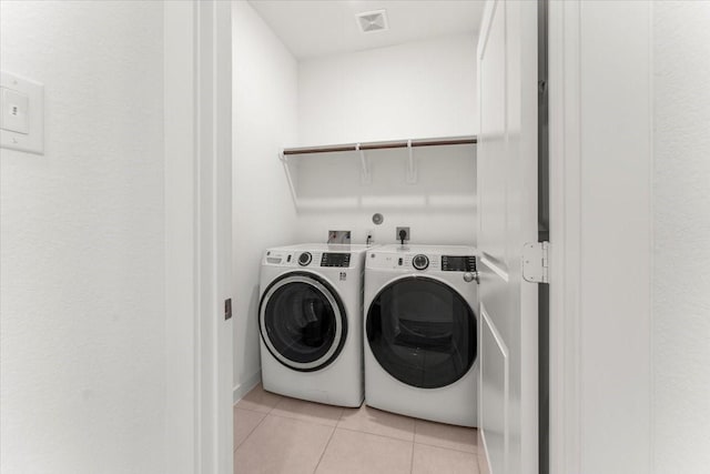 laundry room with laundry area, light tile patterned flooring, independent washer and dryer, and visible vents