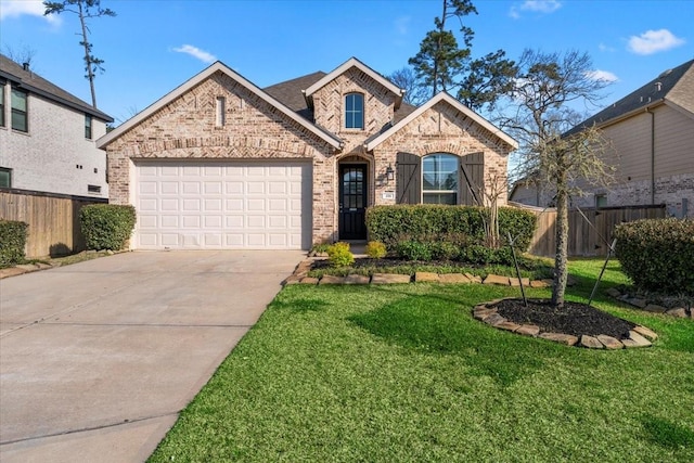 view of front facade featuring a front yard, fence, concrete driveway, and brick siding