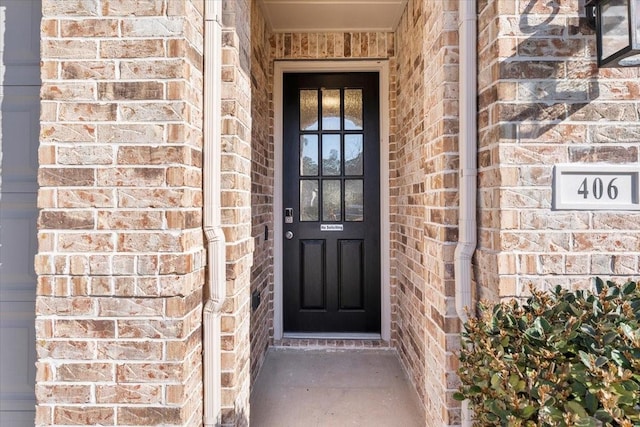 property entrance featuring brick siding