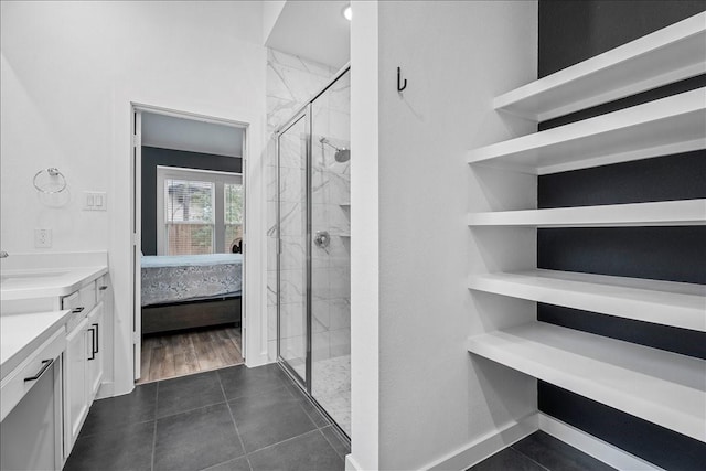 bathroom featuring tile patterned flooring, a shower stall, vanity, and ensuite bathroom