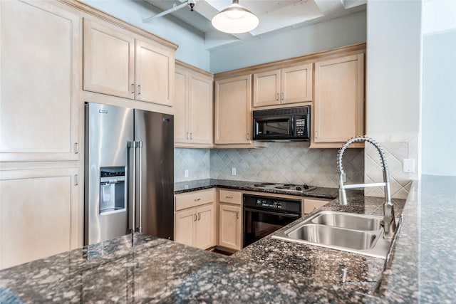 kitchen featuring black microwave, oven, a sink, stainless steel refrigerator with ice dispenser, and backsplash