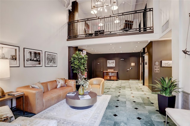 living area with a chandelier and a high ceiling