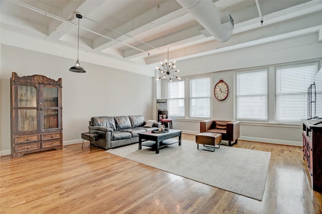 living area featuring light wood-type flooring, coffered ceiling, and baseboards