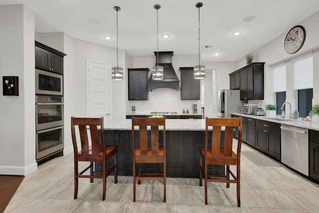 kitchen with stainless steel appliances, premium range hood, a sink, and light stone countertops