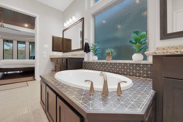 full bathroom with connected bathroom, vanity, a bath, and tile patterned floors