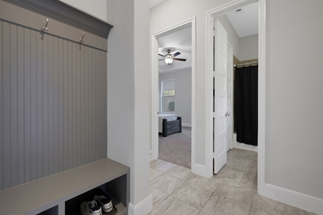 mudroom featuring ceiling fan and baseboards