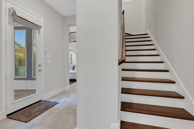 stairs featuring tile patterned flooring and baseboards