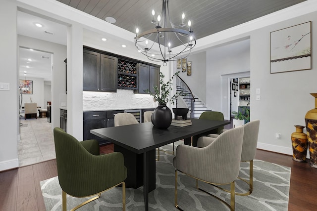 dining area featuring baseboards, wooden ceiling, wood-type flooring, stairs, and a tray ceiling