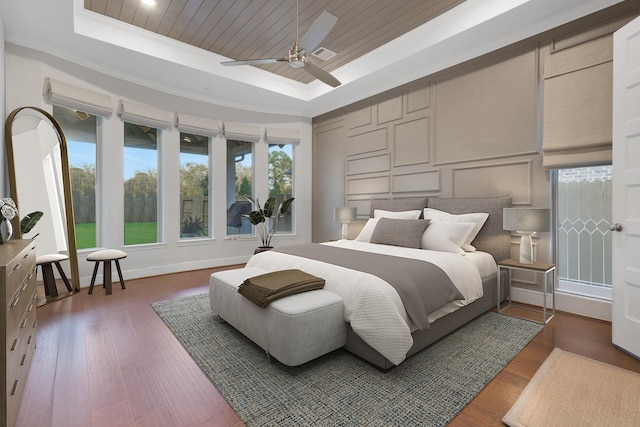 bedroom with wood ceiling, visible vents, a raised ceiling, and a decorative wall