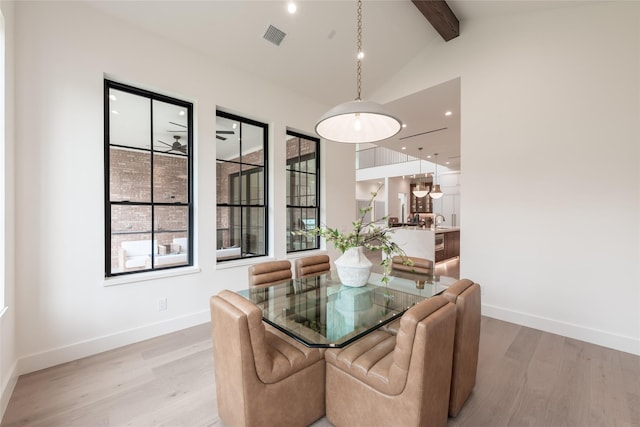 dining space with beam ceiling, visible vents, light wood finished floors, and a healthy amount of sunlight