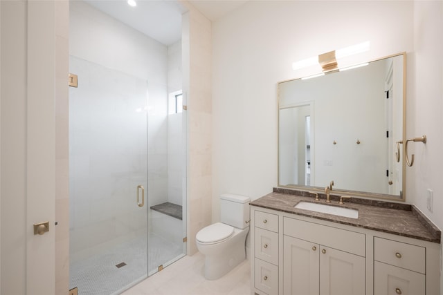 bathroom featuring toilet, a shower stall, and vanity