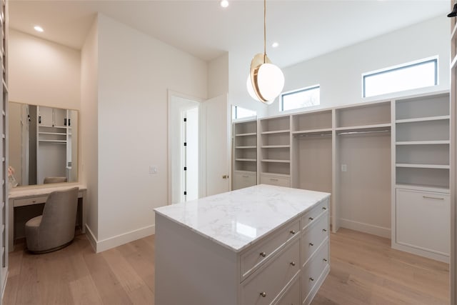 walk in closet with light wood finished floors