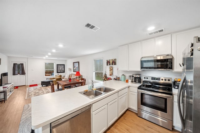 kitchen with open floor plan, stainless steel appliances, a sink, and visible vents