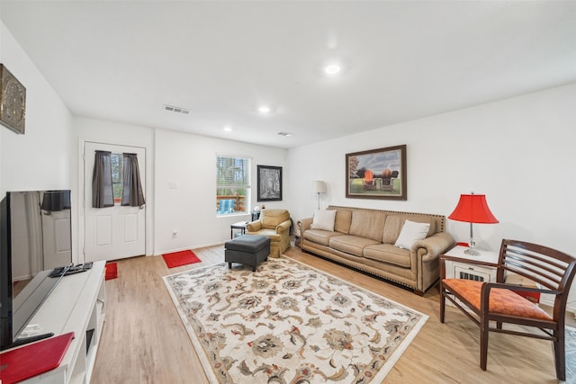 living room featuring light wood-style floors, recessed lighting, and visible vents