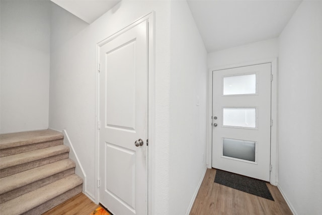 entryway with light wood finished floors and baseboards