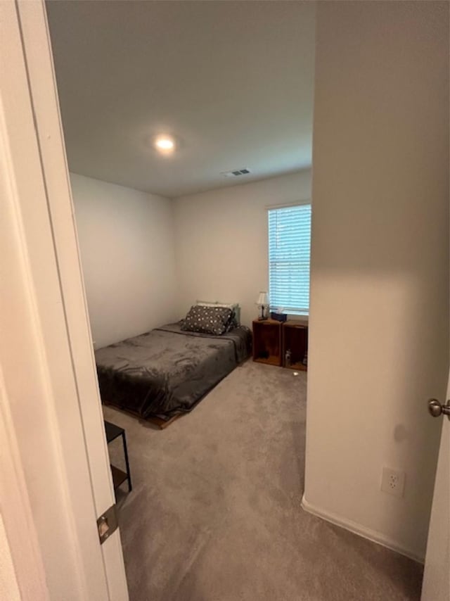 carpeted bedroom featuring visible vents