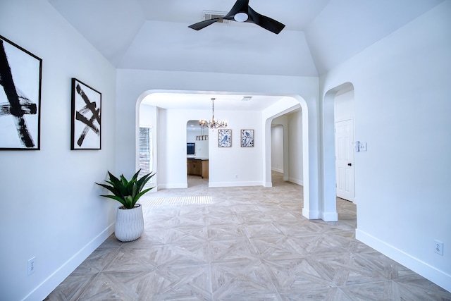 interior space featuring lofted ceiling, arched walkways, and baseboards