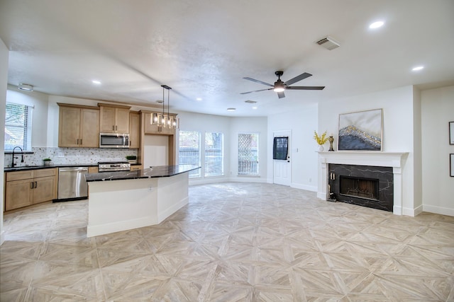 kitchen featuring dark countertops, a fireplace, visible vents, and stainless steel appliances