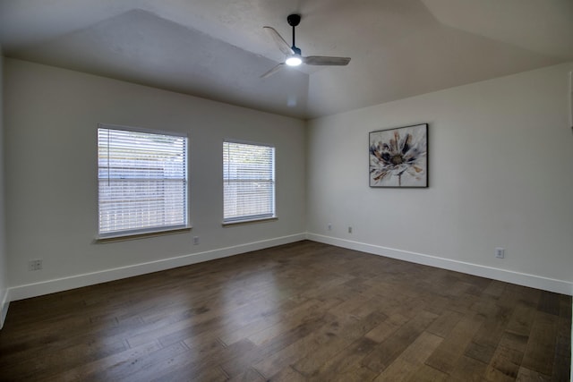 unfurnished room featuring vaulted ceiling, dark wood finished floors, a ceiling fan, and baseboards