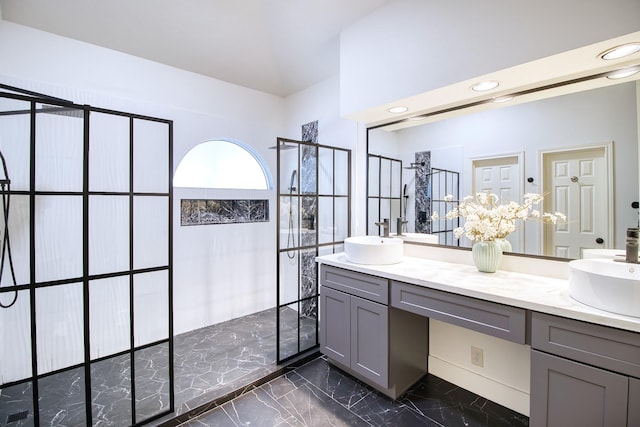 full bathroom featuring marble finish floor, double vanity, a sink, and walk in shower