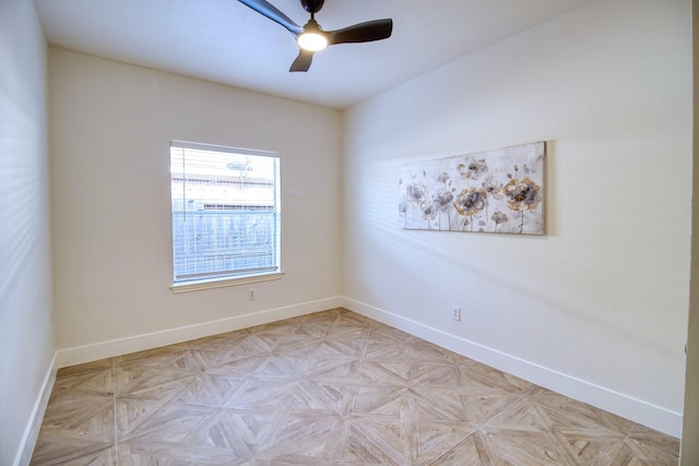 spare room featuring a ceiling fan and baseboards