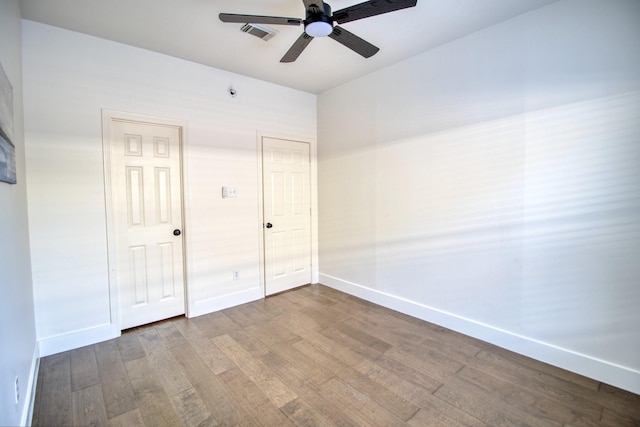 unfurnished bedroom with baseboards, visible vents, ceiling fan, and wood finished floors