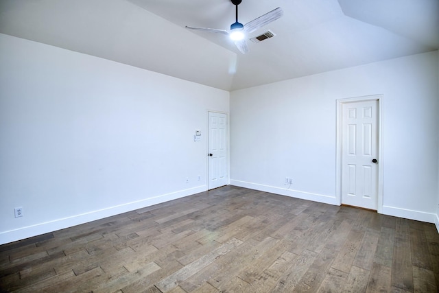 spare room featuring baseboards, visible vents, dark wood-style flooring, and a ceiling fan