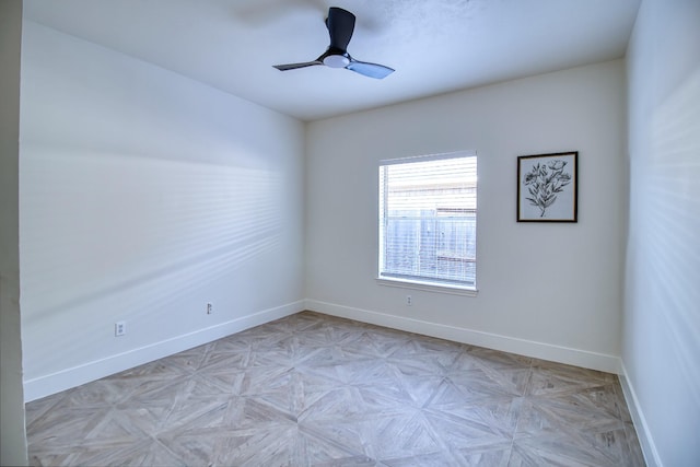 unfurnished room featuring a ceiling fan and baseboards