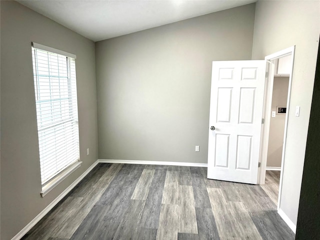 unfurnished room featuring baseboards and wood finished floors