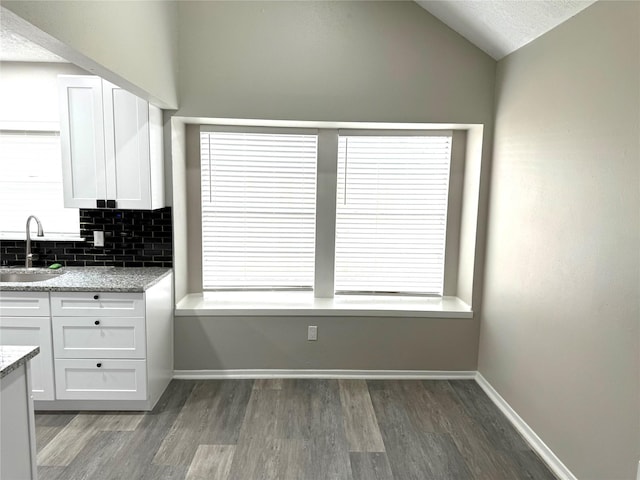 kitchen with wood finished floors, a sink, and white cabinetry