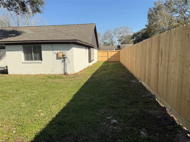 view of property exterior featuring a fenced backyard, a yard, brick siding, and roof with shingles