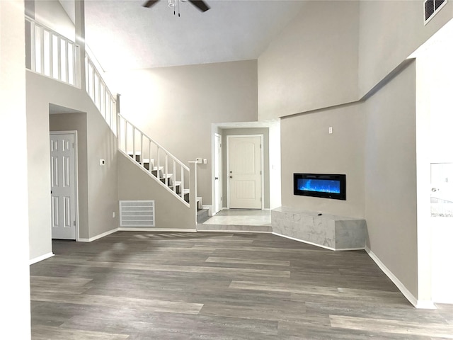 unfurnished living room featuring baseboards, wood finished floors, visible vents, and a ceiling fan