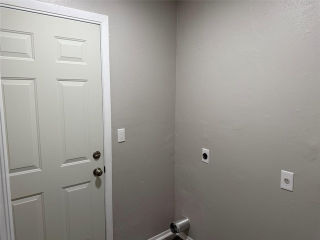 washroom featuring laundry area, a textured wall, and electric dryer hookup