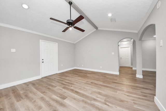 unfurnished living room with arched walkways, lofted ceiling with beams, light wood-type flooring, and baseboards