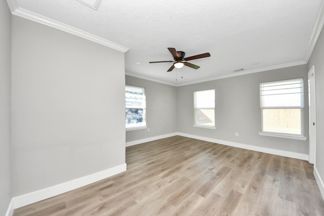 empty room with light wood-style floors, baseboards, and crown molding