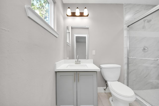 bathroom featuring vanity, a marble finish shower, and toilet