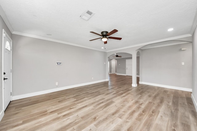 unfurnished living room featuring arched walkways, visible vents, light wood-style flooring, and baseboards