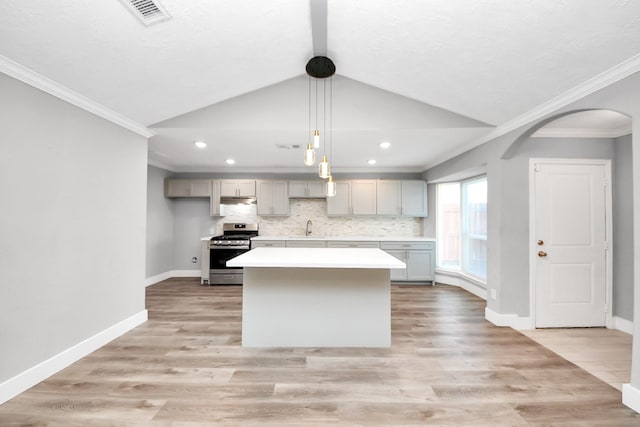 kitchen with light wood finished floors, light countertops, visible vents, stainless steel range with gas stovetop, and a sink