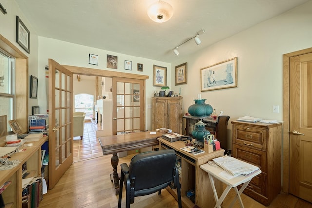 office space with french doors, rail lighting, and light wood-style floors