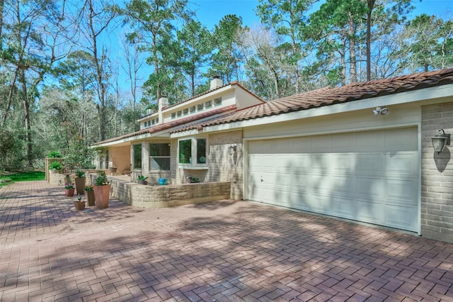 view of front facade featuring decorative driveway and a garage