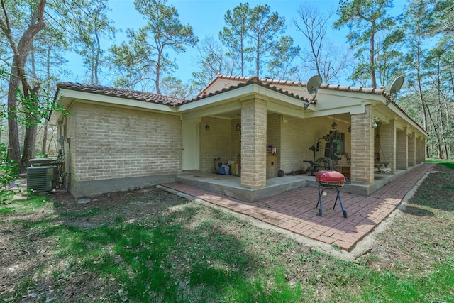 back of house with a patio area, central AC unit, and a tile roof