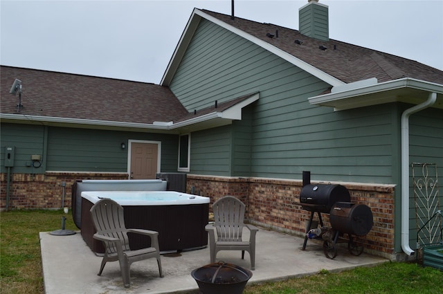 view of patio / terrace with a hot tub and grilling area