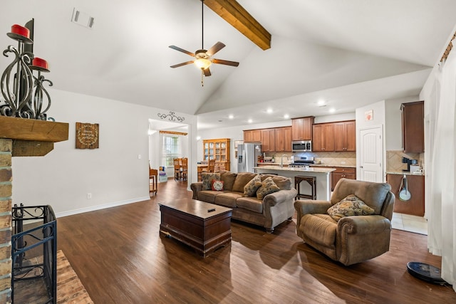 living area with visible vents, beamed ceiling, dark wood-type flooring, a stone fireplace, and high vaulted ceiling